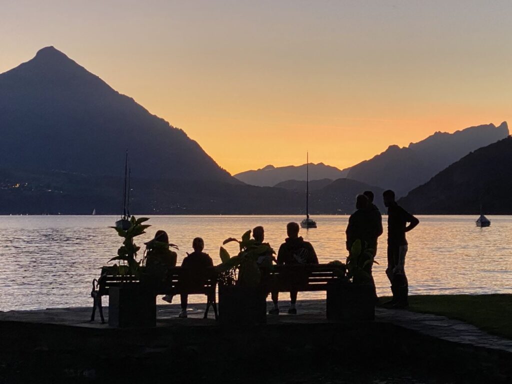Studierende geniessen die freie Zeit am Thunersee mit Blick auf den Niesen